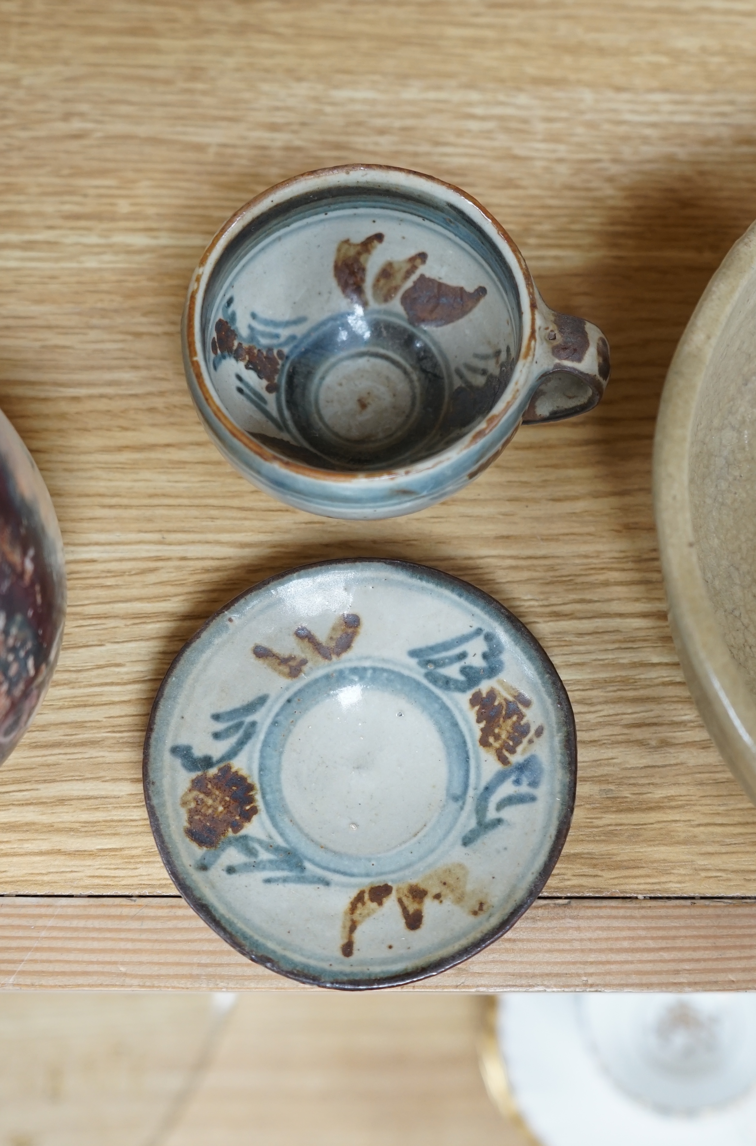 Three pieces of glazed studio pottery comprising a bowl, vase, and a cup and saucer by Seth Cardew, stamped to the base, largest 19cm in diameter. Condition - good